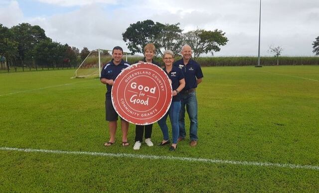 Innisfail United Football Club and Queensland Country Bank holding a cutout of the Good for Good emblem